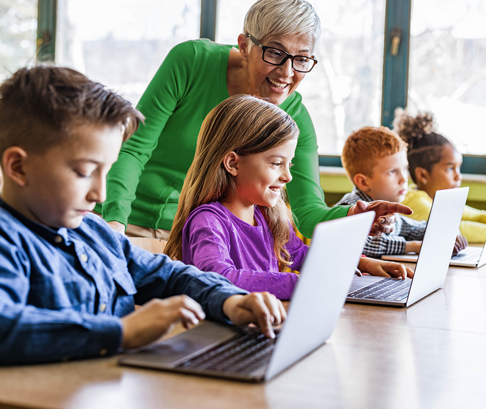 Classroom_Teacher&Students_Laptops_iStock-1327072542_1000x843